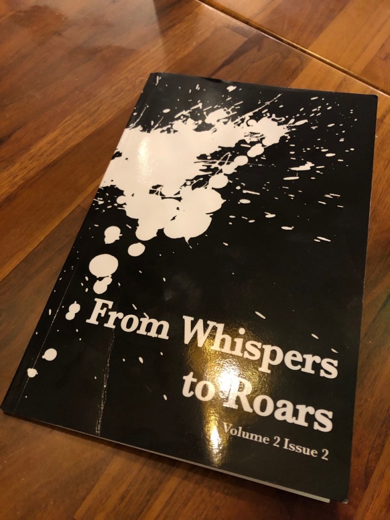 From Whispers to Roars Volume 2 Issue 2 cover with white splatters on a black background